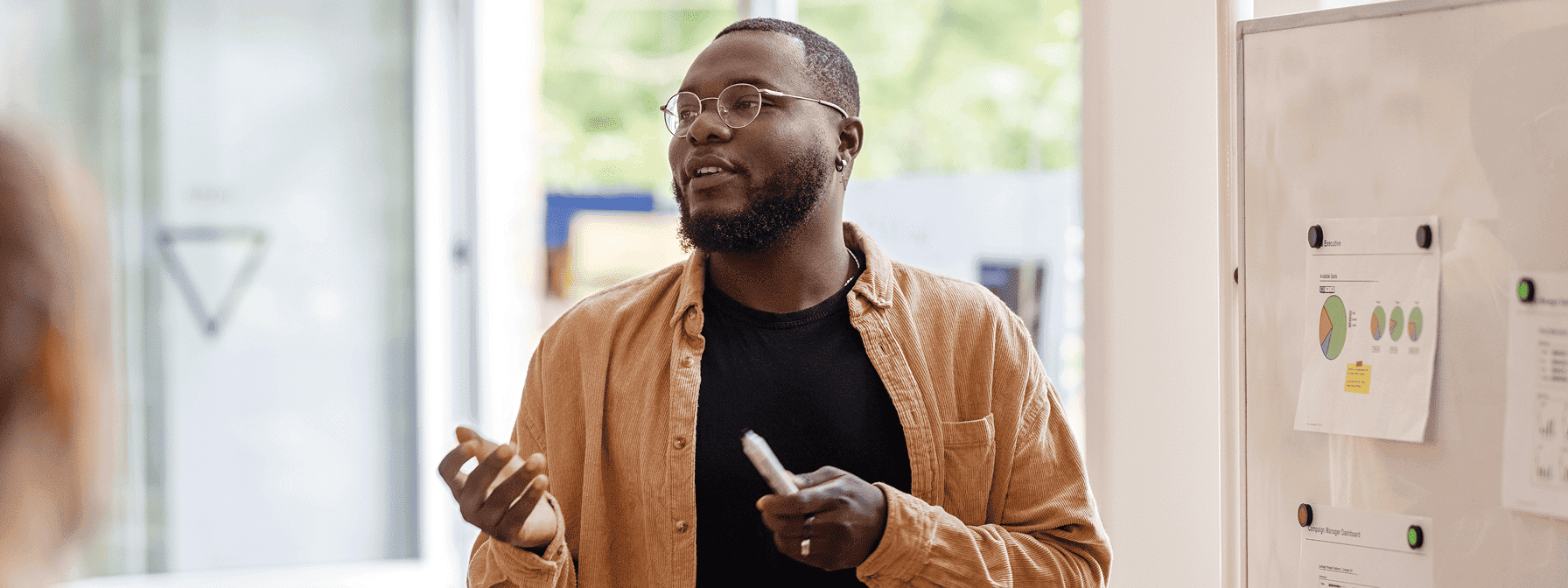 Man in front of a whiteboard discussing a topic